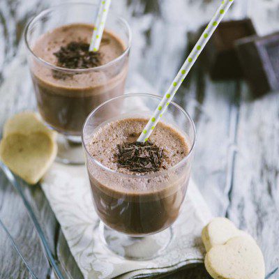 Milkshake al cioccolato in bicchiere con scaglie di cioccolato e cannuccia