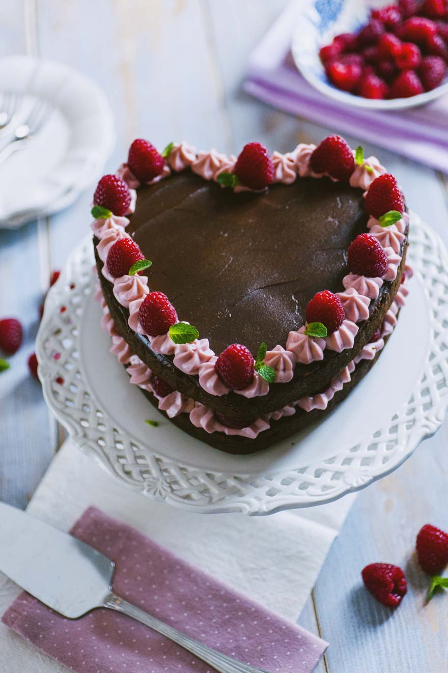 Torta cuore al cioccolato e lamponi, decorata con ganache e lamponi freschi per San Valentino