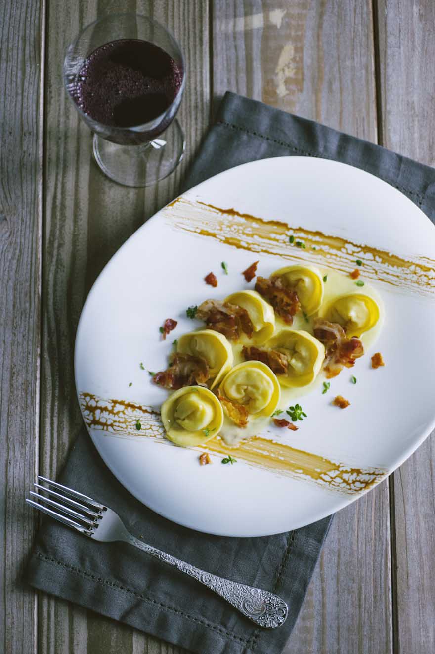 Cappellacci ripieni di patate, saporiti e disposti nel piatto