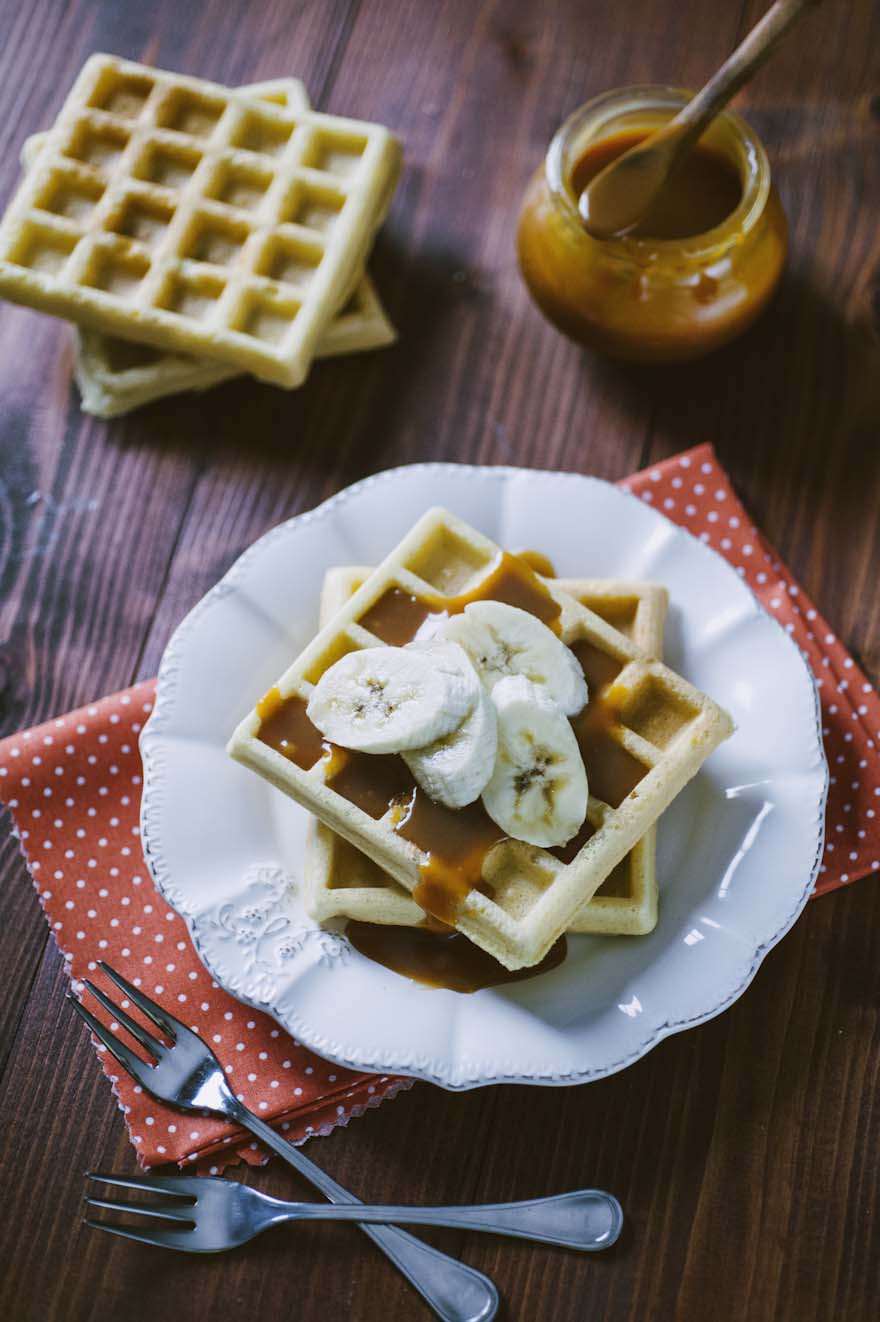 Waffle senza glutine, servito con un velo di salsa al caramello e banane a fette