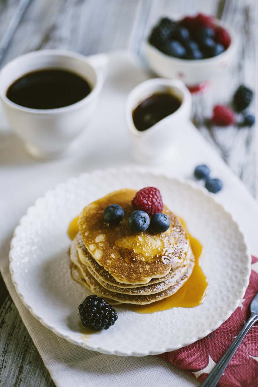 Pancakes senza glutine e latticini, guarniti con sciroppo d'acero e frutta fresca