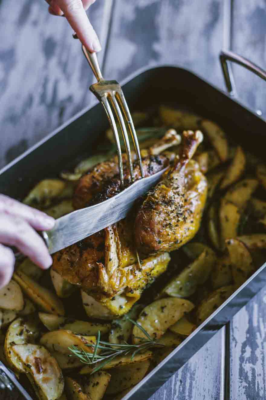 Pollo arrosto con patate, servito direttamente nella teglia calda e pronto al taglio