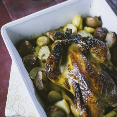 Faraona laccata al miele con patate servita e pronta in teglia