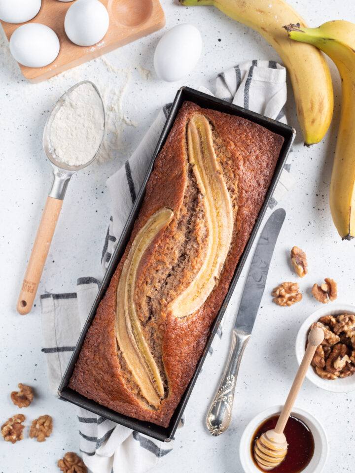 stampo con banana bread intero e ingredienti intorno