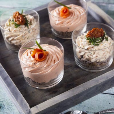 Mousse al salmone e mousse ai pomodori secchi in bicchiere pronti per essere serviti