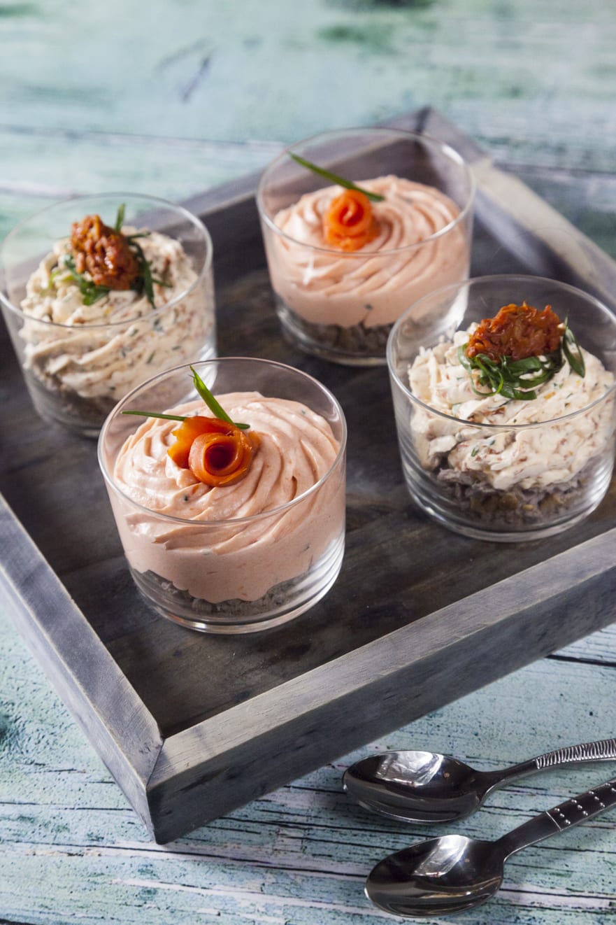 Mousse al salmone e mousse ai pomodori secchi in bicchiere pronti per essere serviti