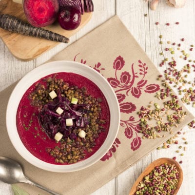 Zuppa di legumi e farro con vellutata di barbabietola pronta per essere servita