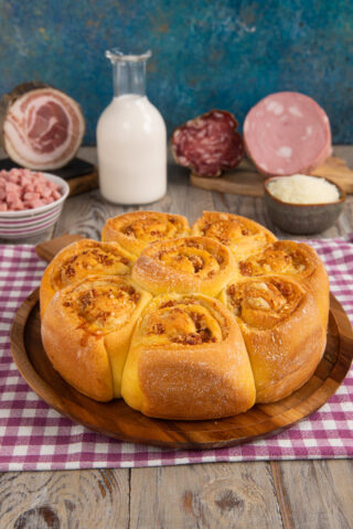 Una torta salata dalla forma originale, in cui delle rose di pasta racchiudono un goloso ripieno di salumi e formaggi