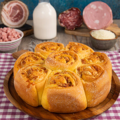 Una torta salata dalla forma originale, in cui delle rose di pasta racchiudono un goloso ripieno di salumi e formaggi