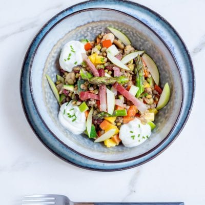 Insalata di verdure, cereali, speck e salsa allo skyr pronta per l'assaggio