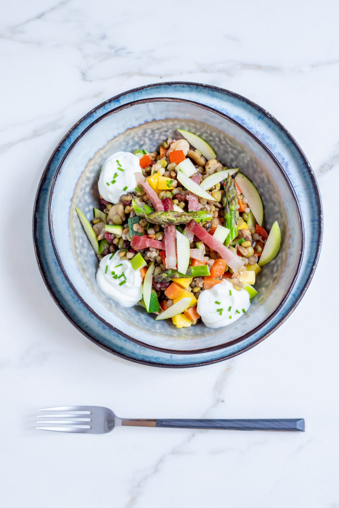 Insalata di verdure, cereali, speck e salsa allo skyr pronta per l'assaggio