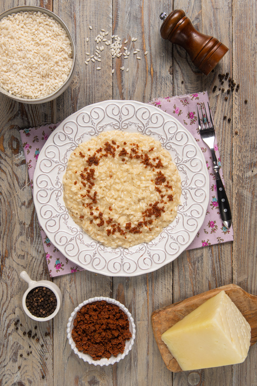 piatto con risotto cacio e pepe con polvere di prosciutto 