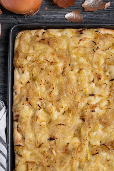 La focaccia con le cipolle è un lievitato fragrante e dorato, che unisce il sapore neutro con qualche nota sapida dell'impasto con la dolcezza della cipolla