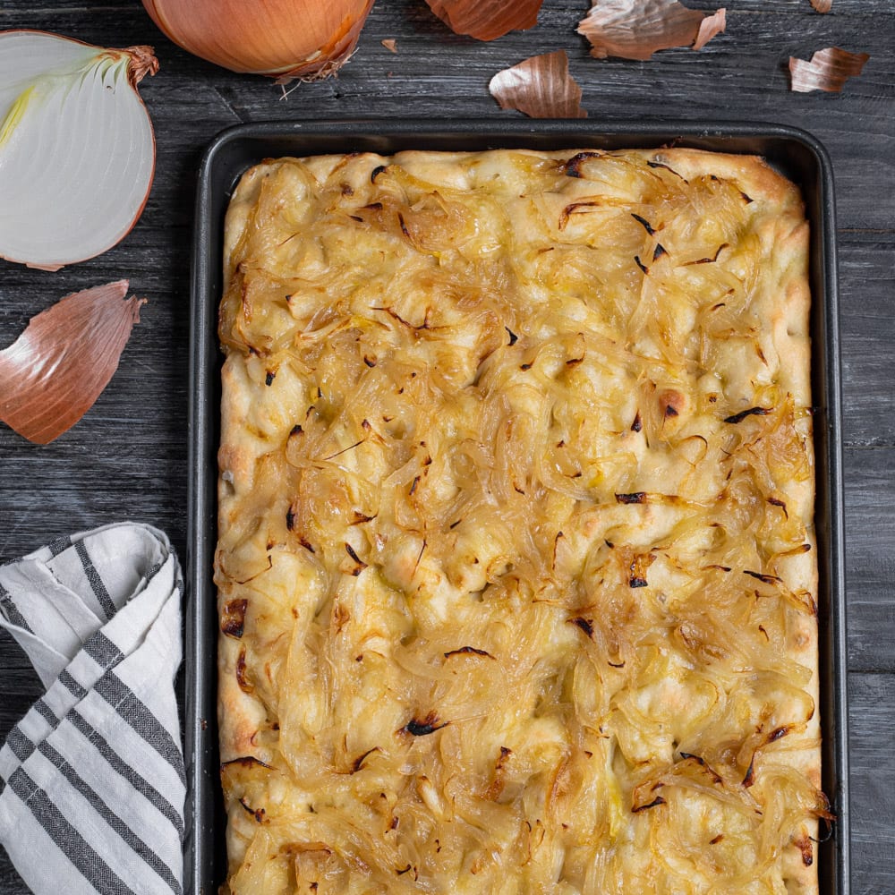La focaccia con le cipolle è un lievitato fragrante e dorato, che unisce il sapore neutro con qualche nota sapida dell'impasto con la dolcezza della cipolla