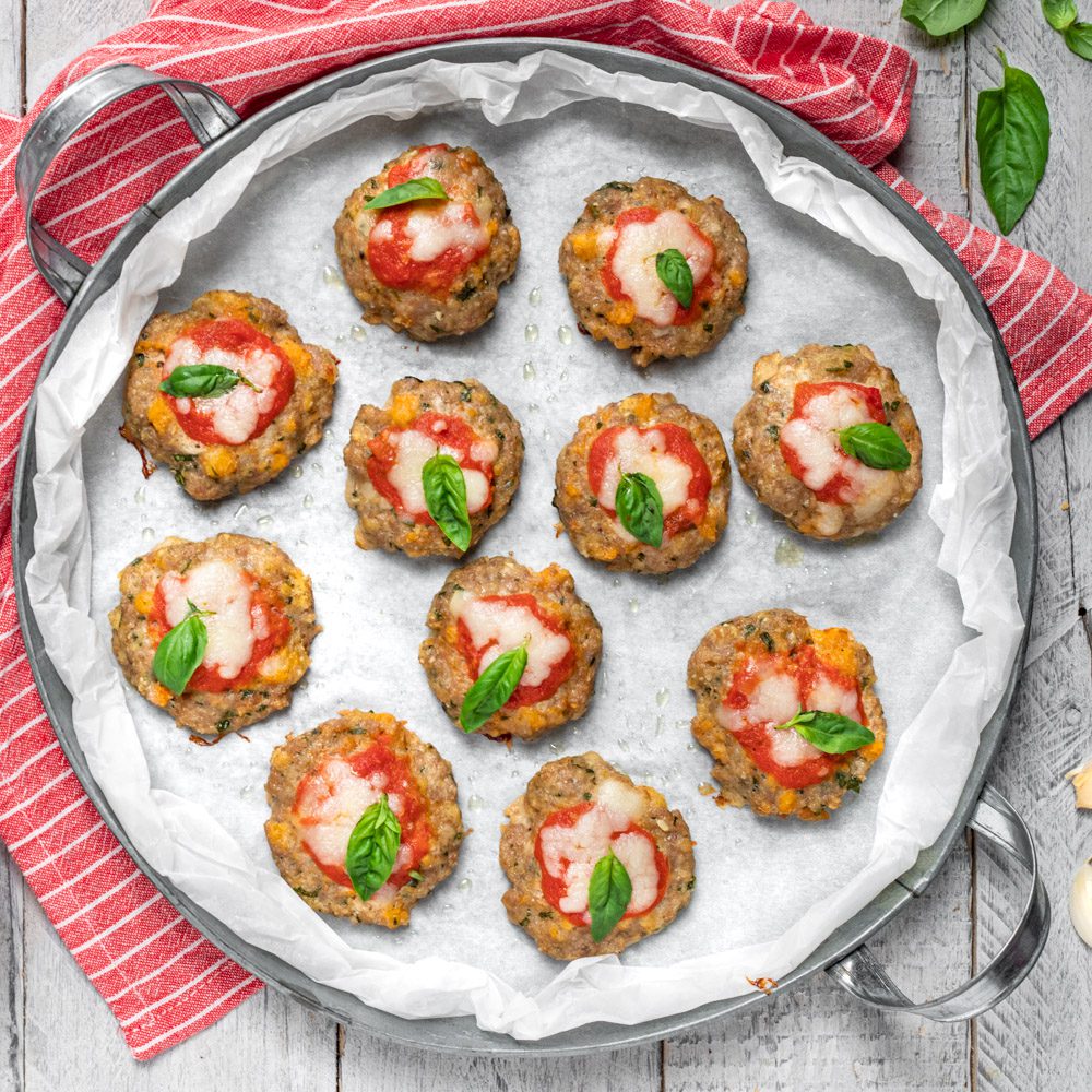 Sembrano tradizionali pizzette ma in realtà sono delle polpettine di carne, farcite in superficie con pomodoro, formaggio e basilico e cotte al forno