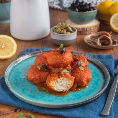 Polpette di branzino alla mediterranea su piatto azzurro