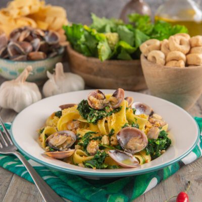 pappardelle vongole e cime di rapa su piatto bianco