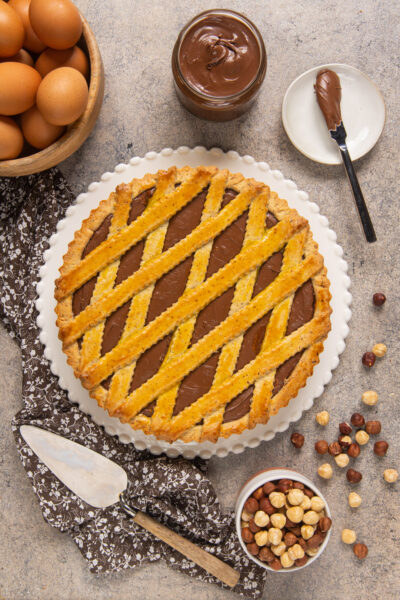 La crostata alla nutella è un dolce goloso, in cui la pasta frolla incontra la crema spalmabile al cioccolato e nocciole