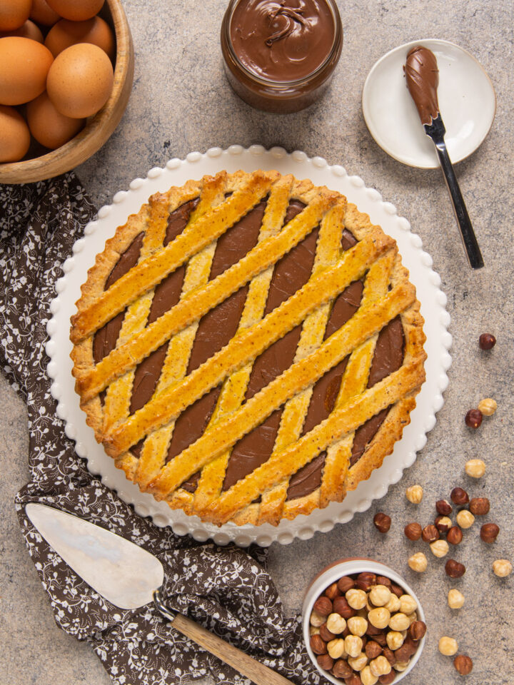 La crostata alla nutella è un dolce goloso, in cui la pasta frolla incontra la crema spalmabile al cioccolato e nocciole