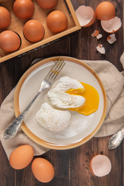 Uova in camicia aperte con forchetta argentata e gusci