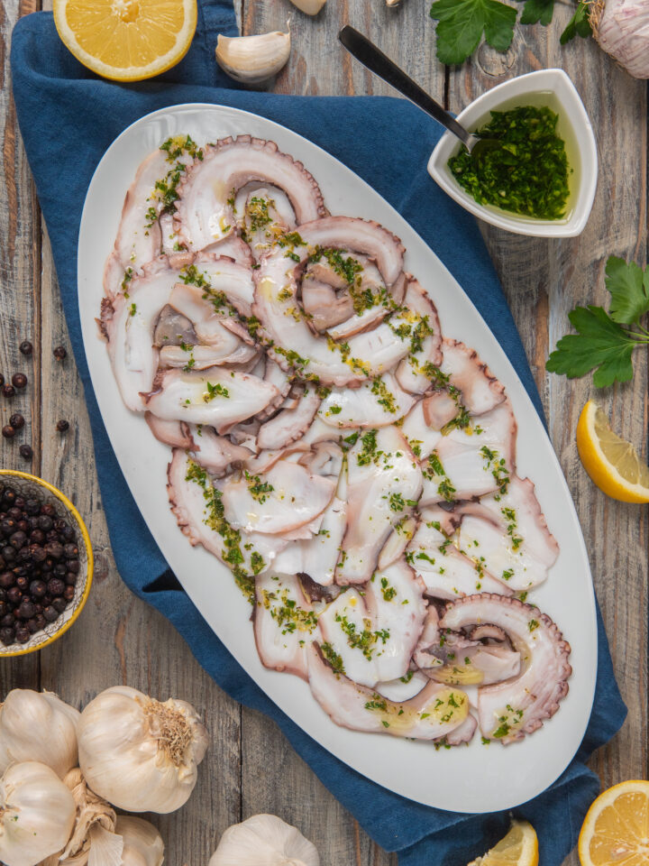 piatto di portata con carpaccio di polpo e condimenti