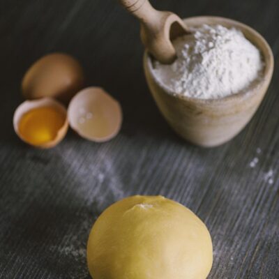 Sfera di pasta fresca all'uovo con uova aperte e farina