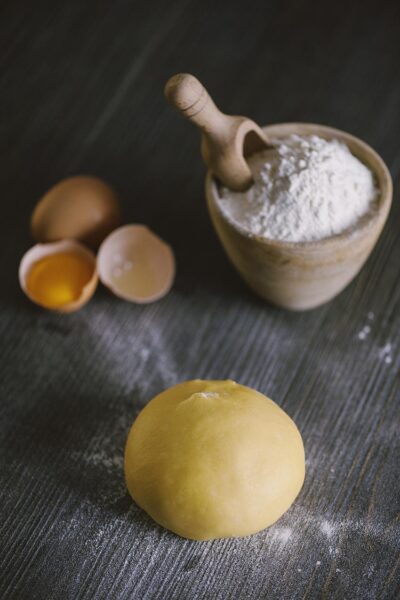 Sfera di pasta fresca all'uovo con uova aperte e farina