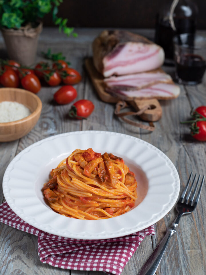 piatto di portata con spaghetti all'amatriciana e ingredienti