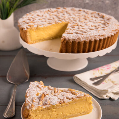 Torta della nonna Un guscio di pasta frolla ripieno di crema pasticcera e ricoperto di pinoli
