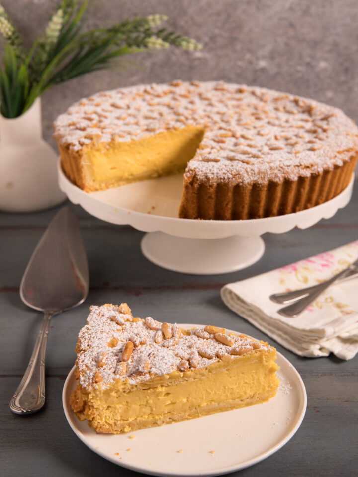 Torta della nonna Un guscio di pasta frolla ripieno di crema pasticcera e ricoperto di pinoli