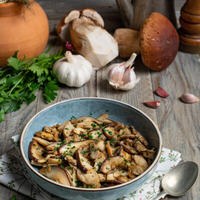 piatto di portata con funghi porcini, aglio e prezzemolo