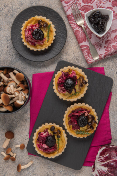 ardesia con mini quiche, radicchio, funghi e prugne