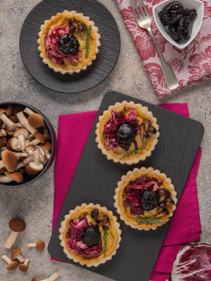 ardesia con mini quiche, radicchio, funghi e prugne