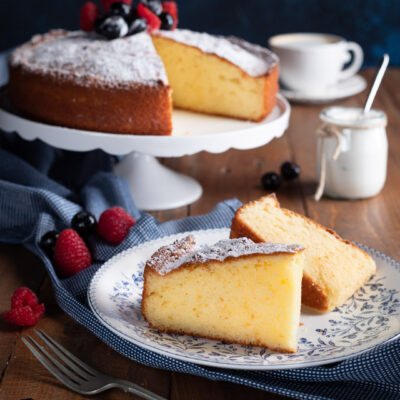 fetta di torta allo yogurt in. primo piano e torta su alzatina