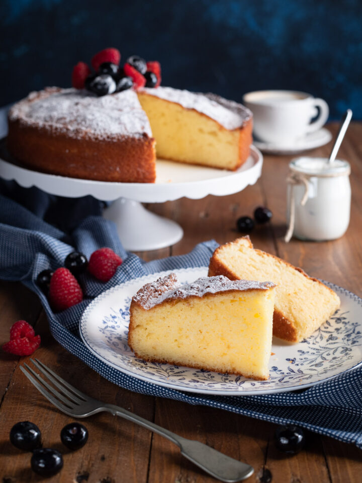 fetta di torta allo yogurt in. primo piano e torta su alzatina