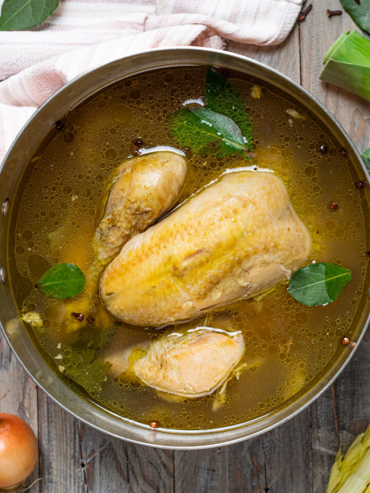 pollo lesso intero nel suo brodo e foglie di alloro