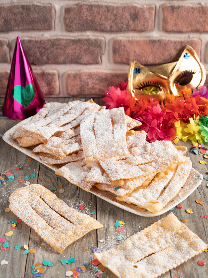 Chiacchiere con zucchero maschera di carnevale e stelle filanti