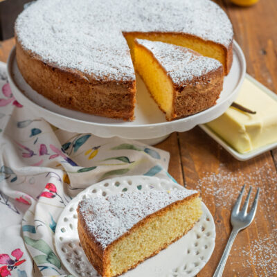 Torta paradiso con zucchero a velo, limoni, burro, uova e forchetta da dolce