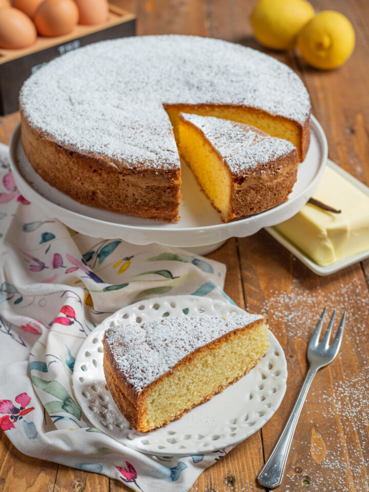 Torta paradiso con zucchero a velo, limoni, burro, uova e forchetta da dolce