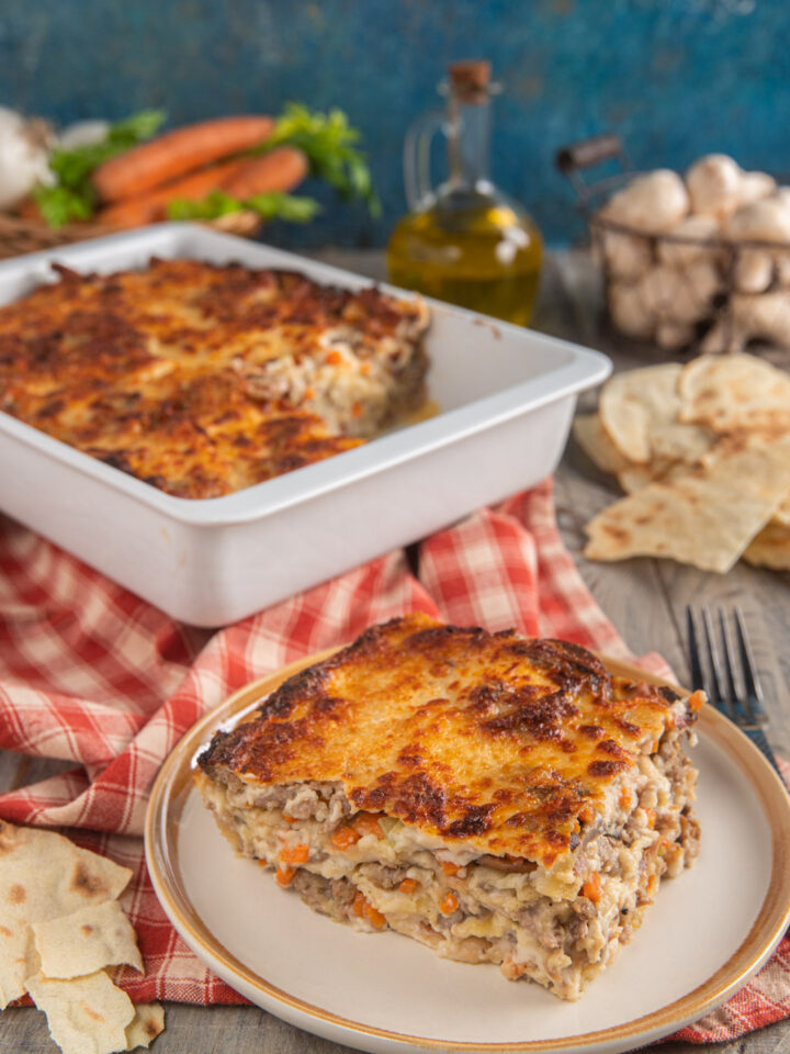 Lasagne di pane carasau con salsiccia e funghi con monoporzione e tovagliolo a quadretti bianchi e rossi