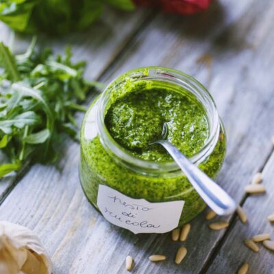 vasetto di vetro con pesto di rucola e cucchiaino