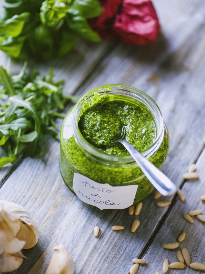 vasetto di vetro con pesto di rucola e cucchiaino