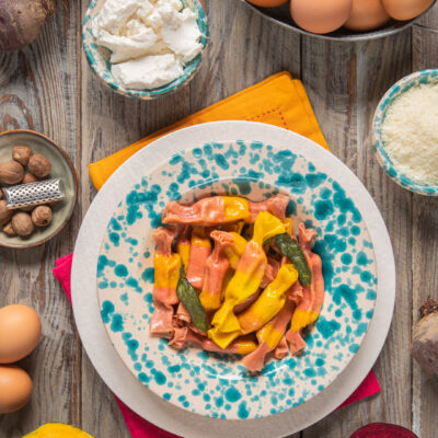 Ravioli caramella con tovaglioli rosso e arancio, ricotta, noce moscata e uova intere