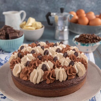 torta caffè e cioccolato su piatto da portata con decorazione di ganashe e chicchi di caffè