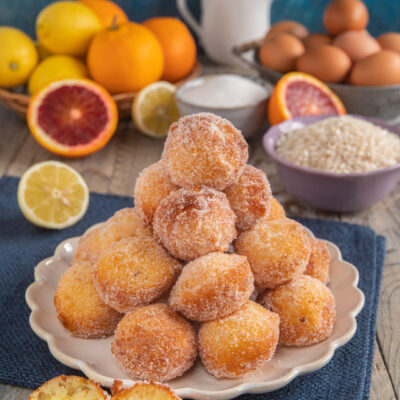 piatto da portata con frittelle di riso e frittella a metà in primo piano