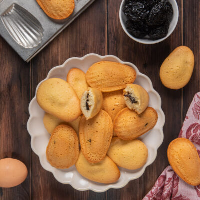 Madeleines con cuore di prugne con stampo e ciotolina di prugne secche