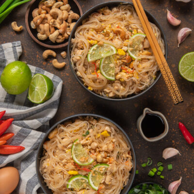 Pad thai in 2 ciotole con bacchette cinesi, salsa di soia e ciotolina di anacardi e lime
