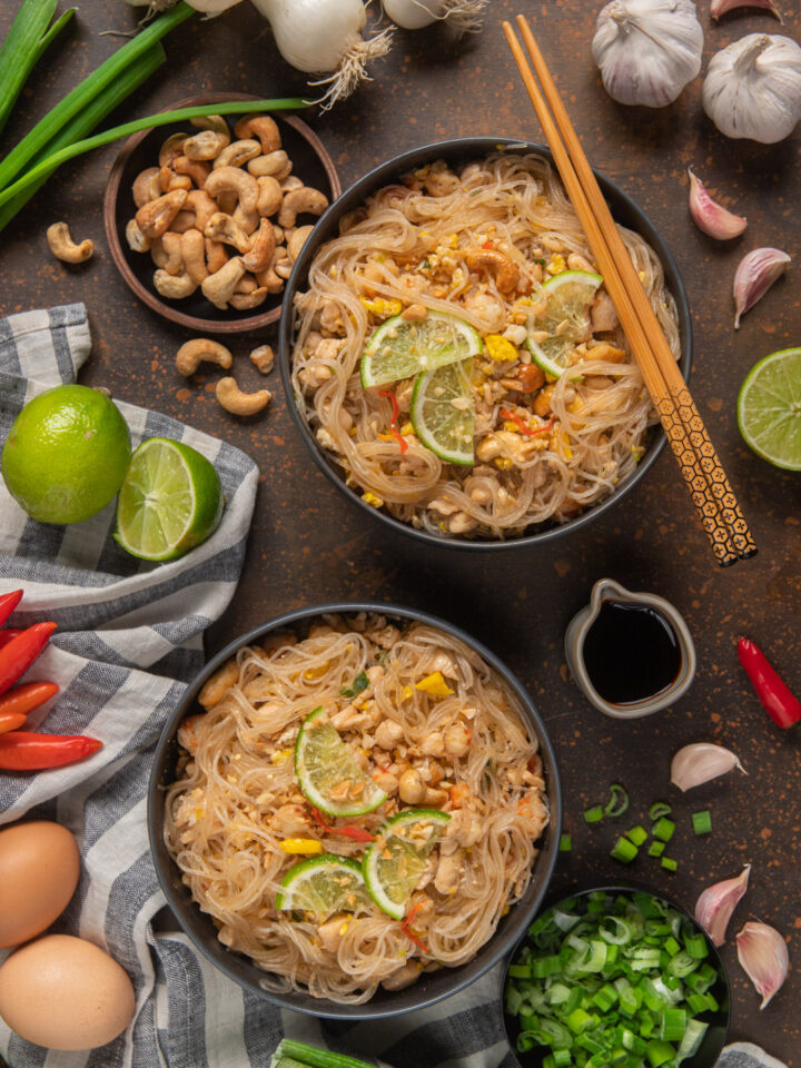 Pad thai in 2 ciotole con bacchette cinesi, salsa di soia e ciotolina di anacardi e lime