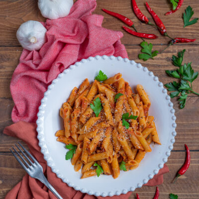 piatta da portata con penne all'arrabbiata, aglio e peperoncini freschi intorno