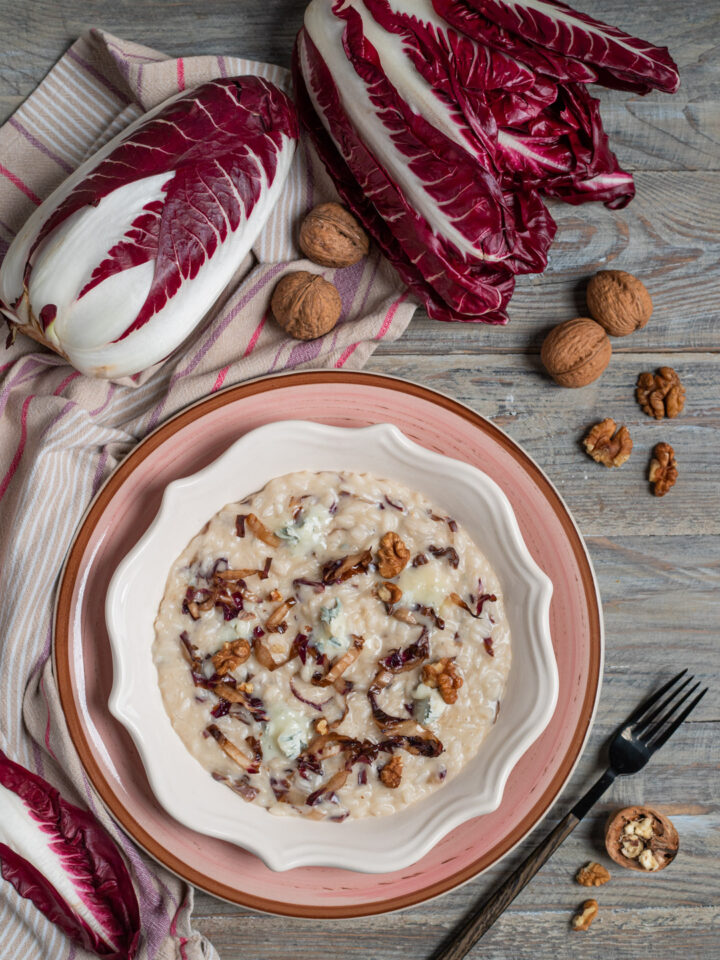 piatto da portata con risotto al radicchio e gorgonzola, cespo di radicchio crudo e noci intorno